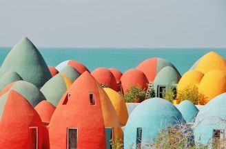 a group of colorfully painted houses next to the ocean