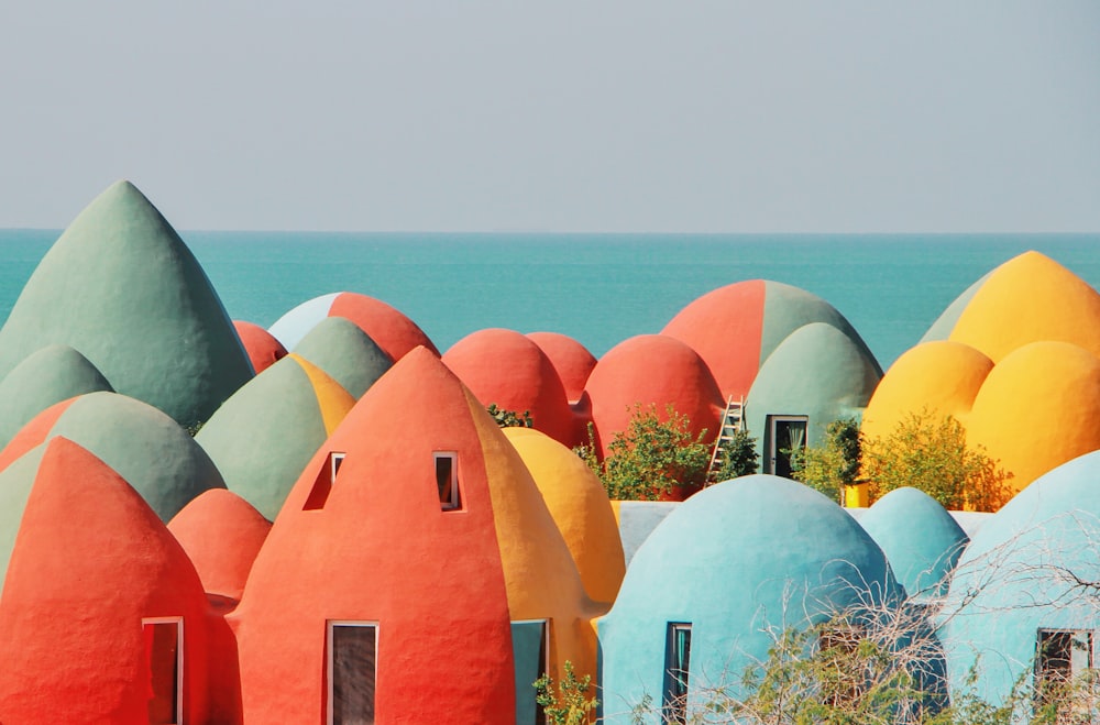 a group of colorfully painted houses next to the ocean