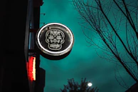 Bar decorated for Día de Muertos with colorful Mexican skull stickers on the walls.