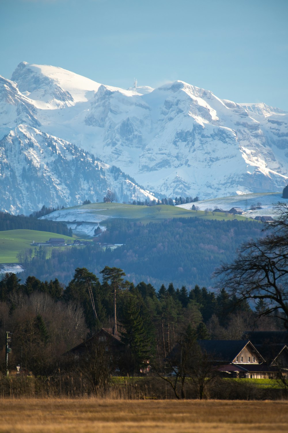 a view of a snowy mountain range with houses in the foreground