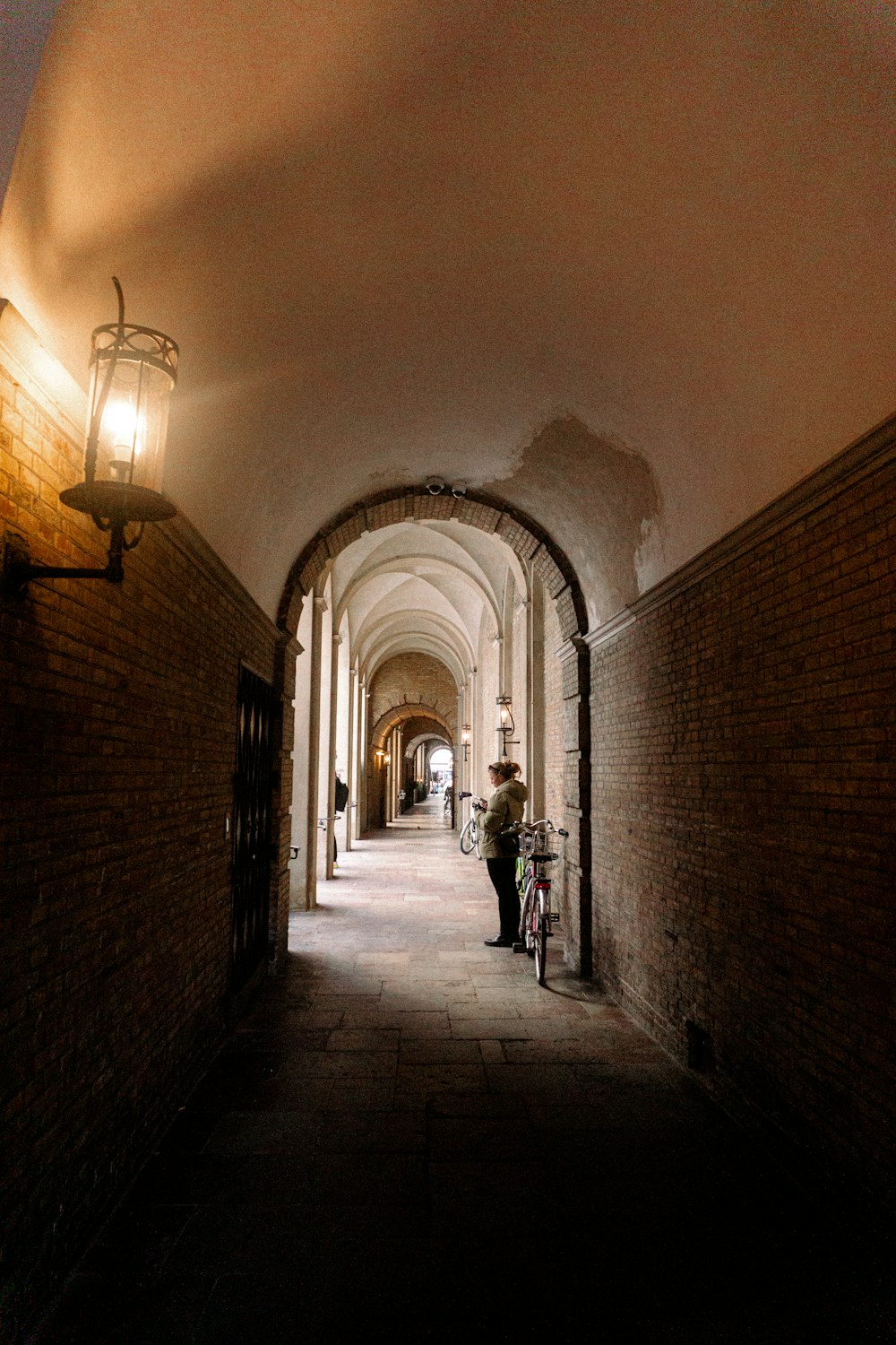 a person walking down a hallway with a bike