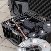 a black case filled with items sitting on top of a tiled floor