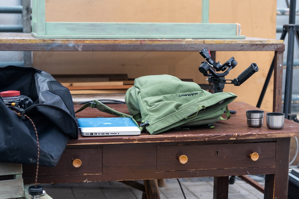 a table with a camera and a backpack on it