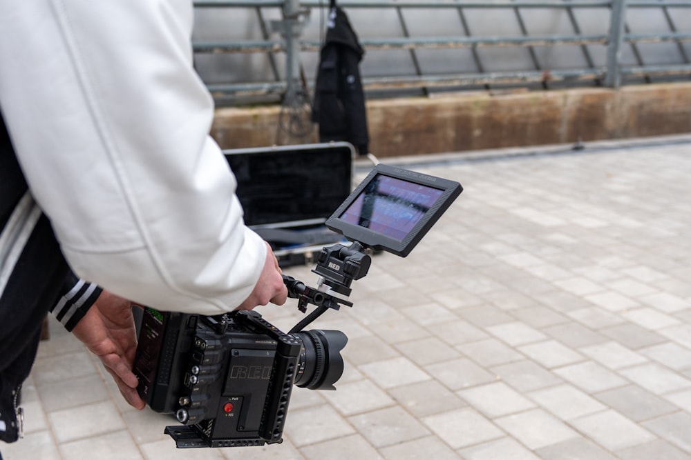 a person holding a camera and a laptop