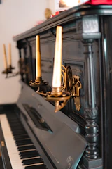 A vintage piano surrounded by sheet music and candlelight.
