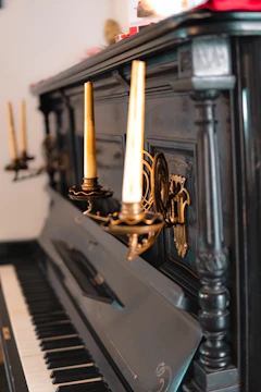 A vintage piano surrounded by sheet music and candlelight.