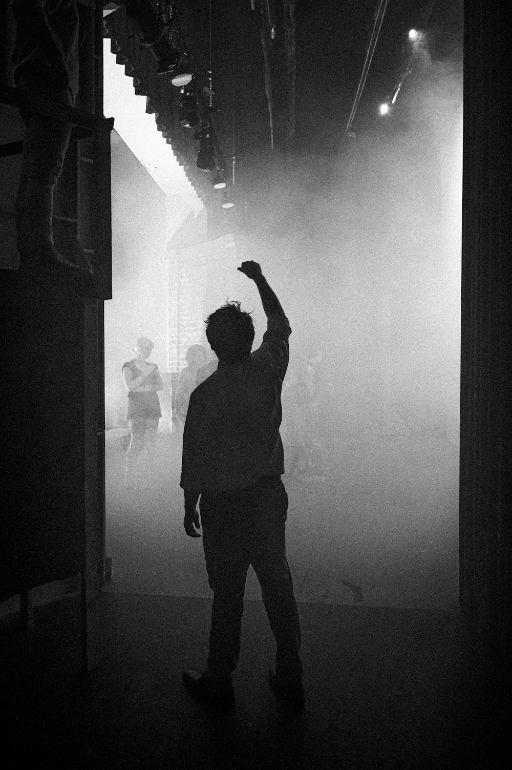 a person standing in a dark room with smoke coming out of the ceiling