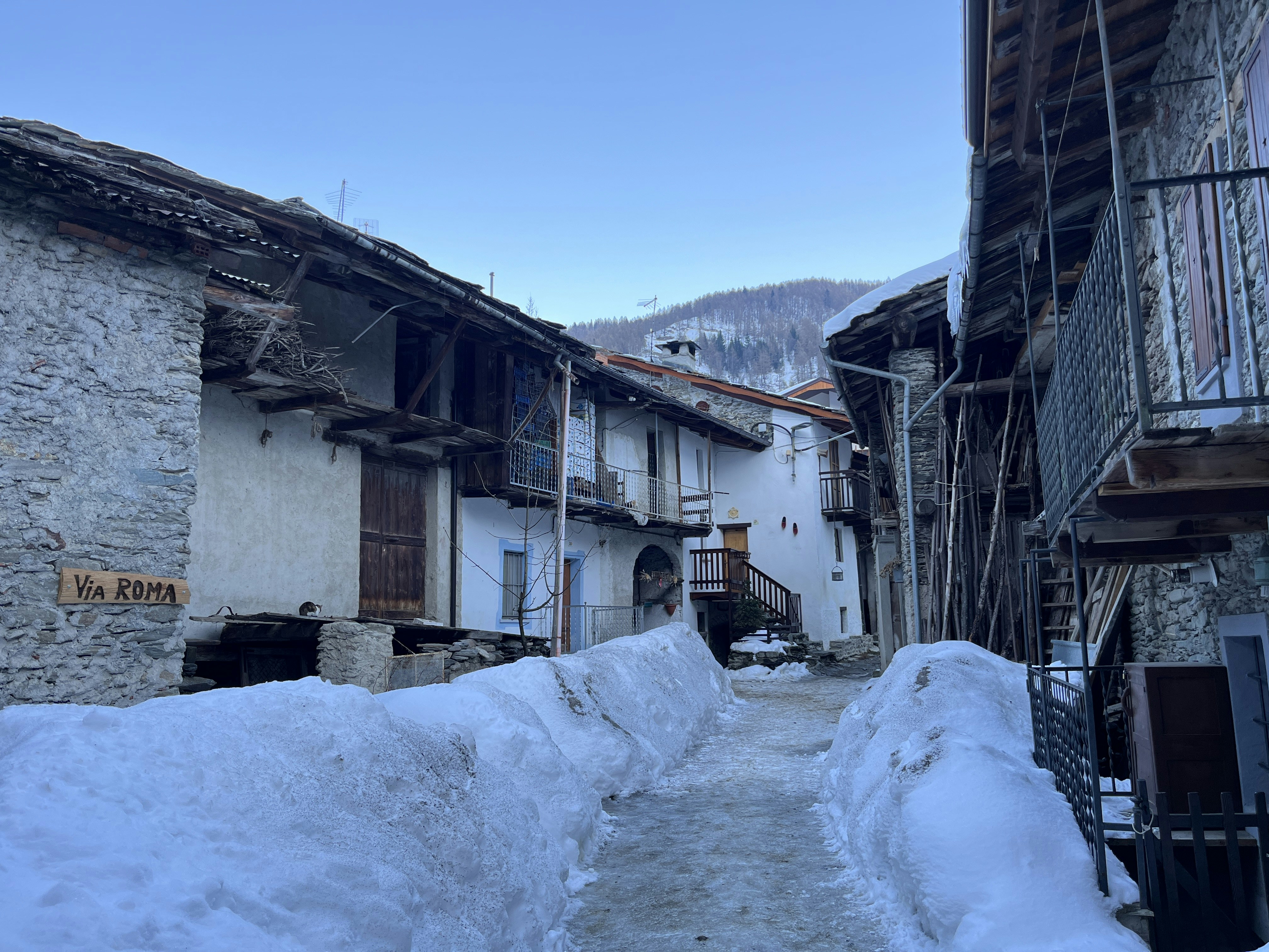 a narrow alley with snow on the ground