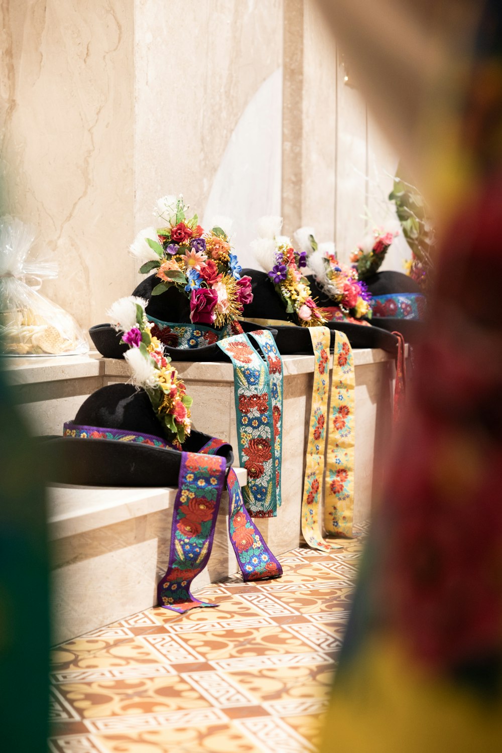 a row of decorated boots sitting on top of a tiled floor