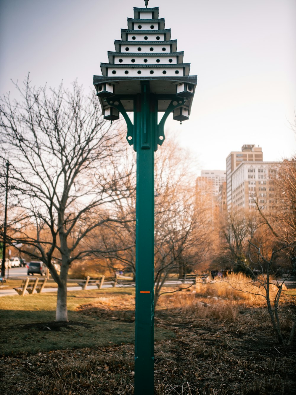 a green pole with a clock on top of it