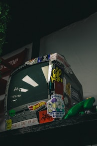 a television sitting on top of a shelf covered in stickers