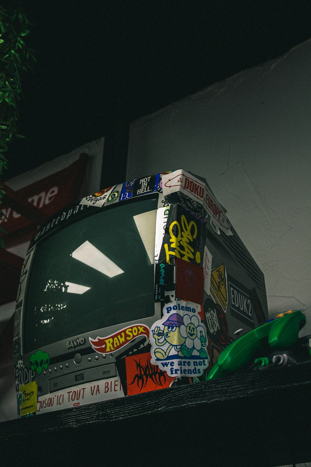 a television sitting on top of a shelf covered in stickers