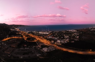 A panoramic view of a coastal town captured by an influencer during golden hour.