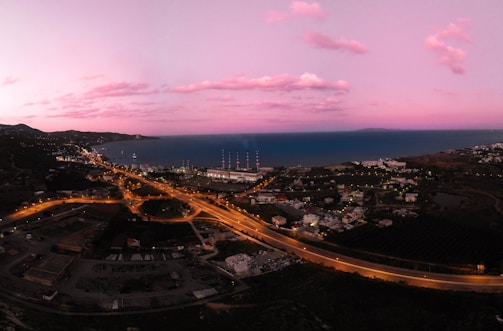 A panoramic view of a coastal town captured by an influencer during golden hour.