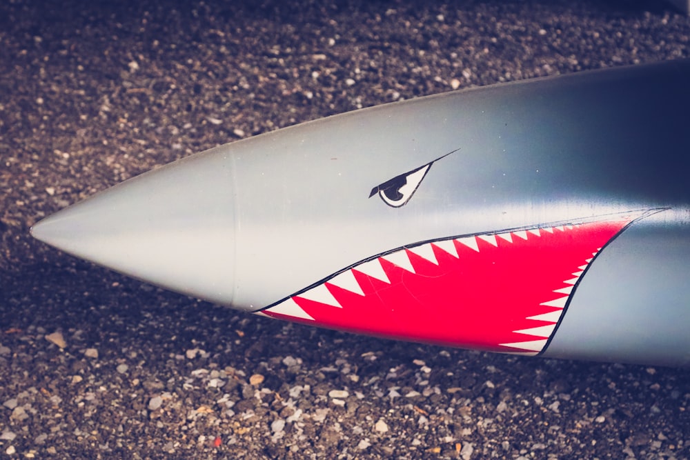 un gros plan d’une planche de surf avec les dents d’un requin peintes dessus