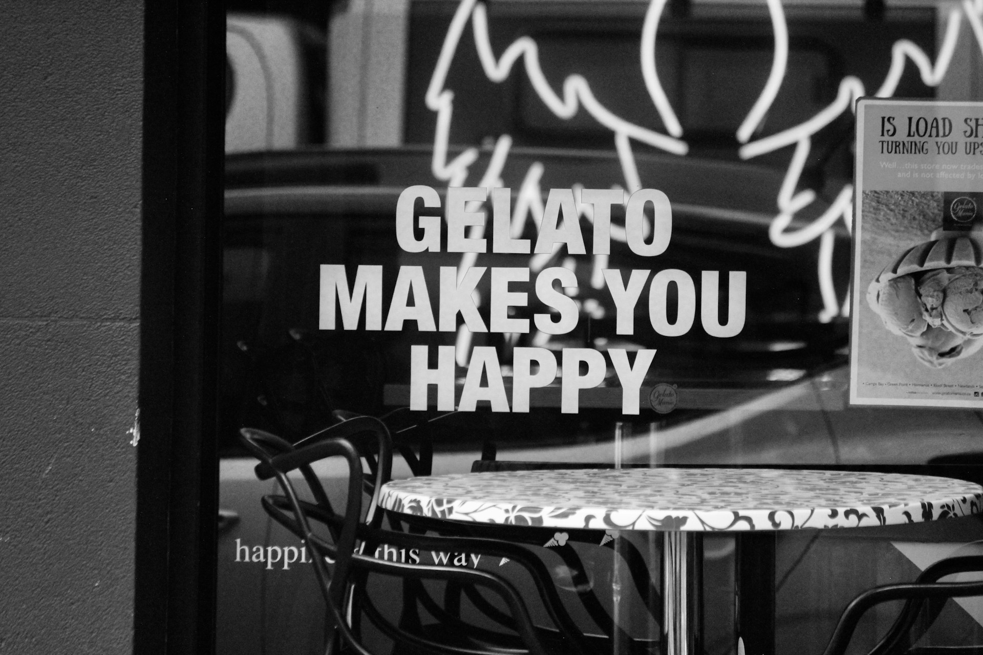 a table and chairs in front of a store window