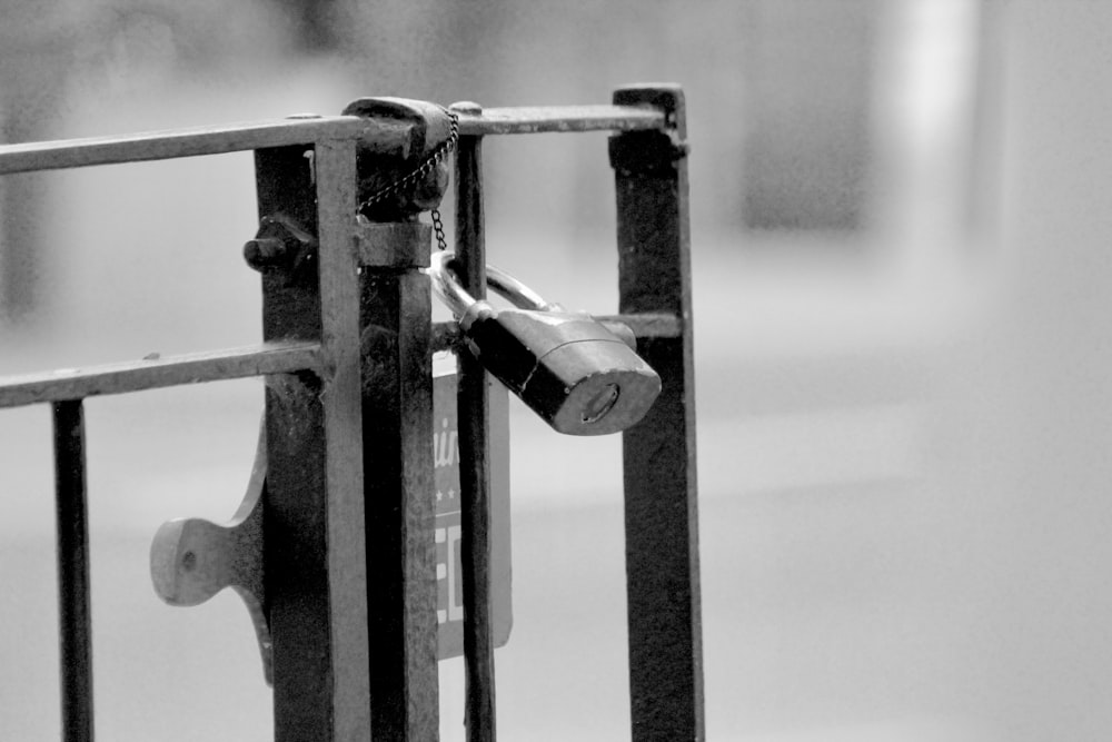 a black and white photo of a lock on a gate