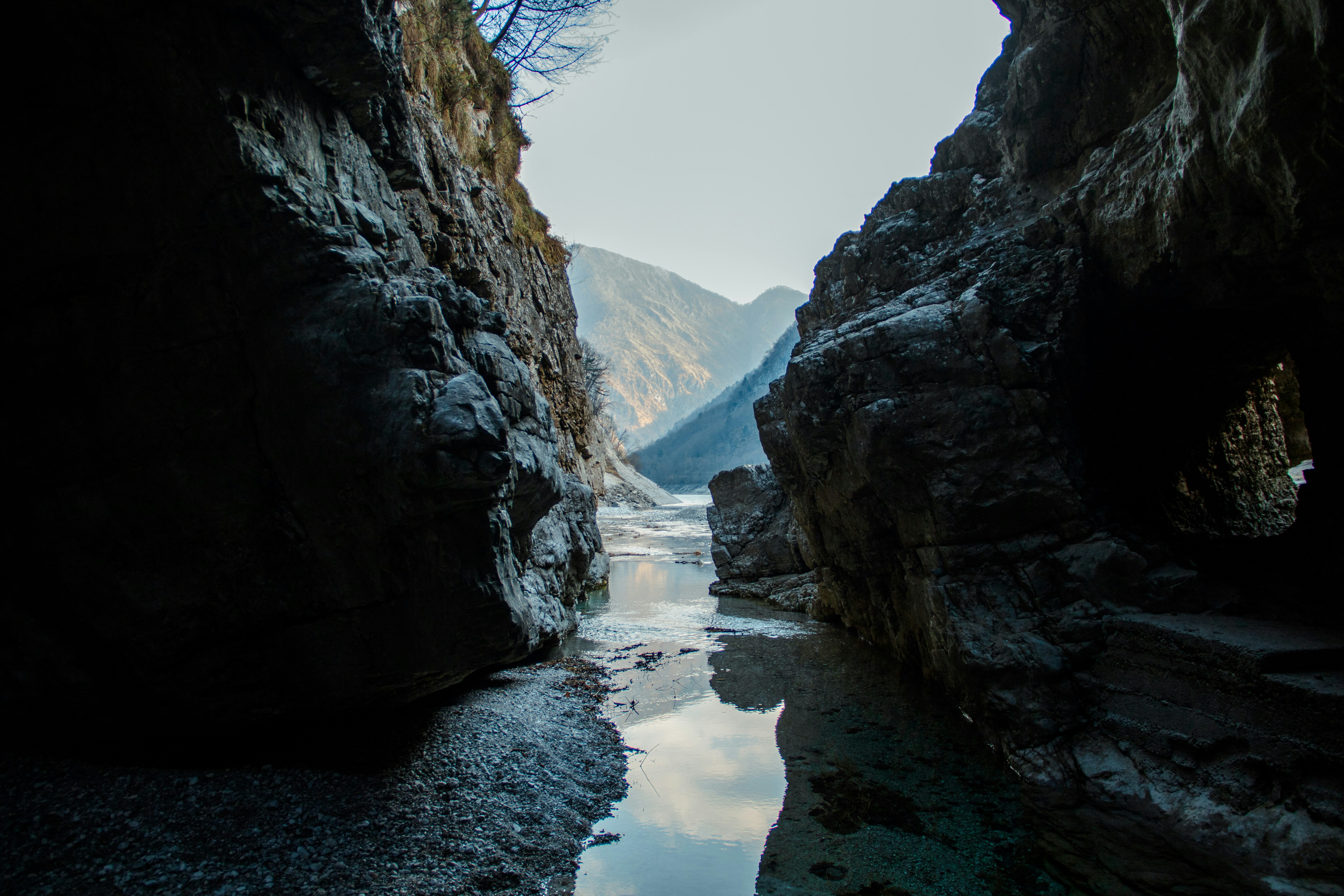 This photo captures the breathtaking beauty of a mountain lake surrounded by majestic peaks. The still, crystal-clear water stretches out as far as the eye can see, reflecting the surrounding mountain range and the blue sky above. The rugged, rocky terrain of the mountains provides a stunning contrast to the softness of the water, creating a dramatic and awe-inspiring landscape.