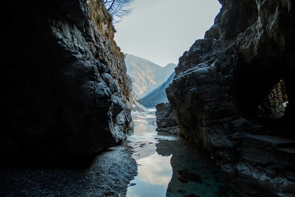 a river running through a rocky canyon next to a mountain