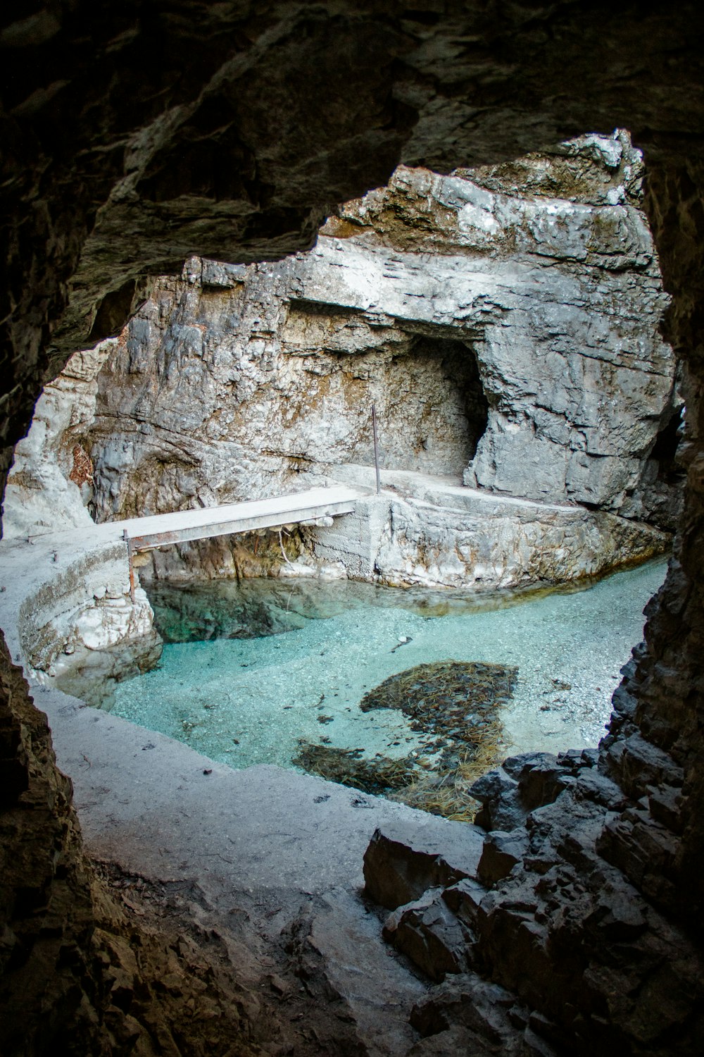 a pool in a cave with a bench in it