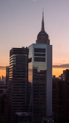A city skyline at sunset highlighting buildings developed by Sanidhya Real Estate Co.