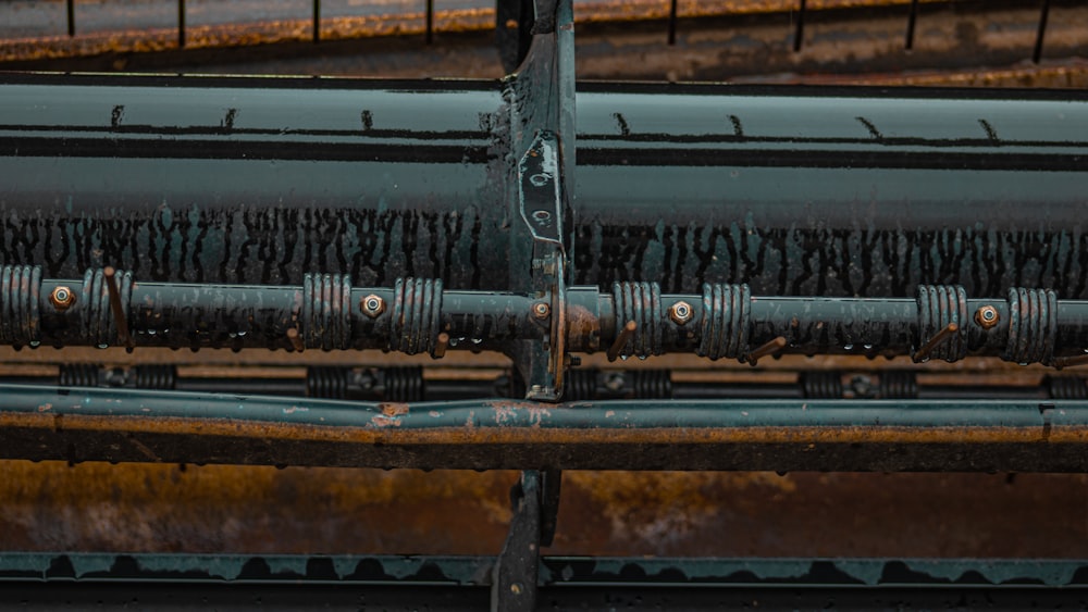 a close up of a metal structure with a train in the background