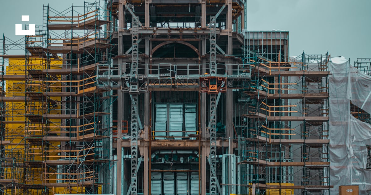 A very tall building with lots of scaffolding around it photo – Free ...