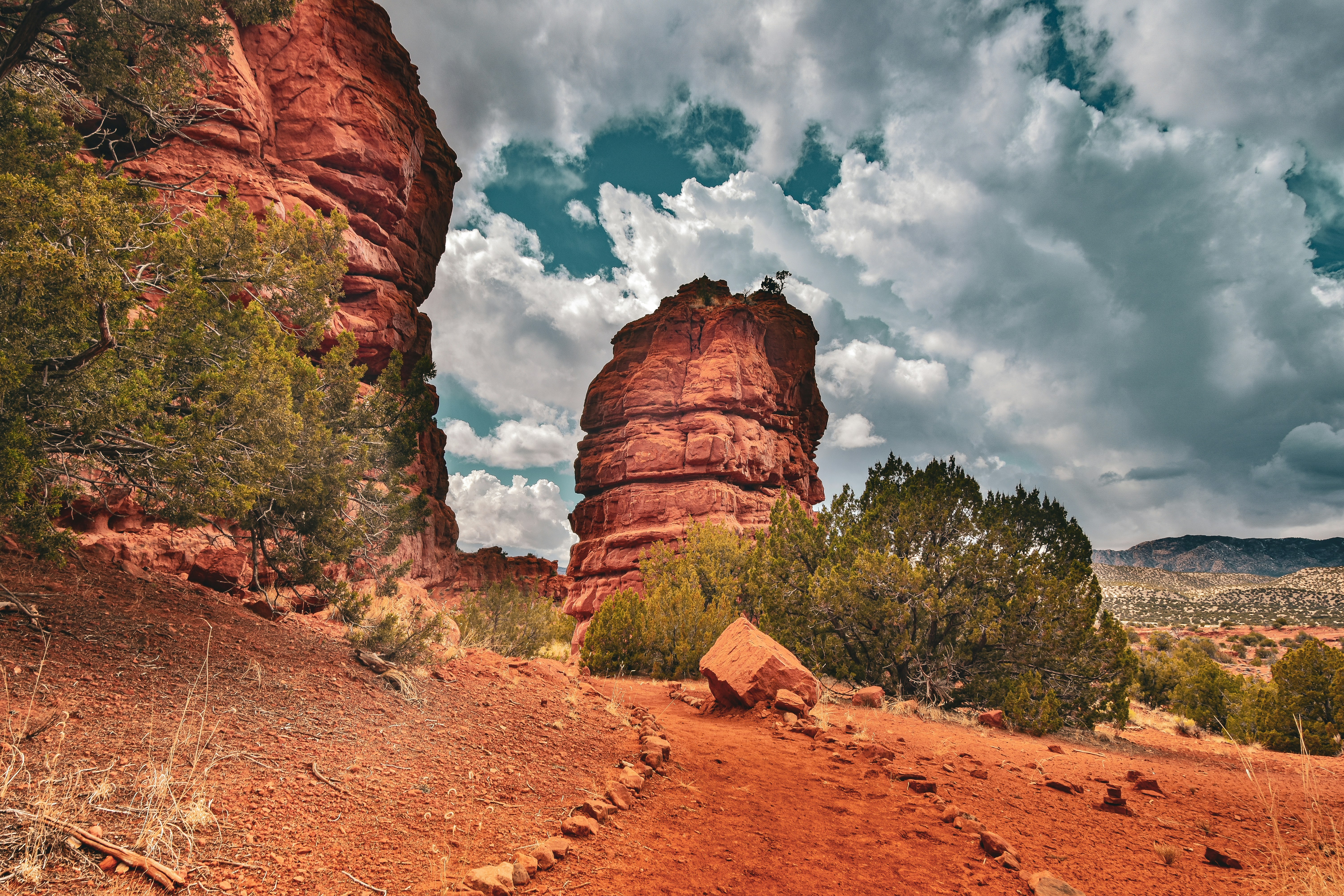a dirt path with a rock formation in the background