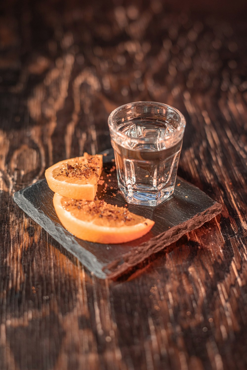 a glass of water sitting on top of a wooden table