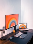 A clean workspace featuring dual monitors displaying Office365 and Google Workspace dashboards.