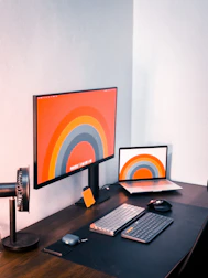 An organized workspace featuring a computer screen with workflow apps open.