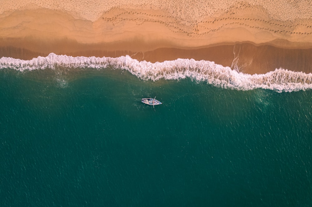 an aerial view of a boat in the ocean