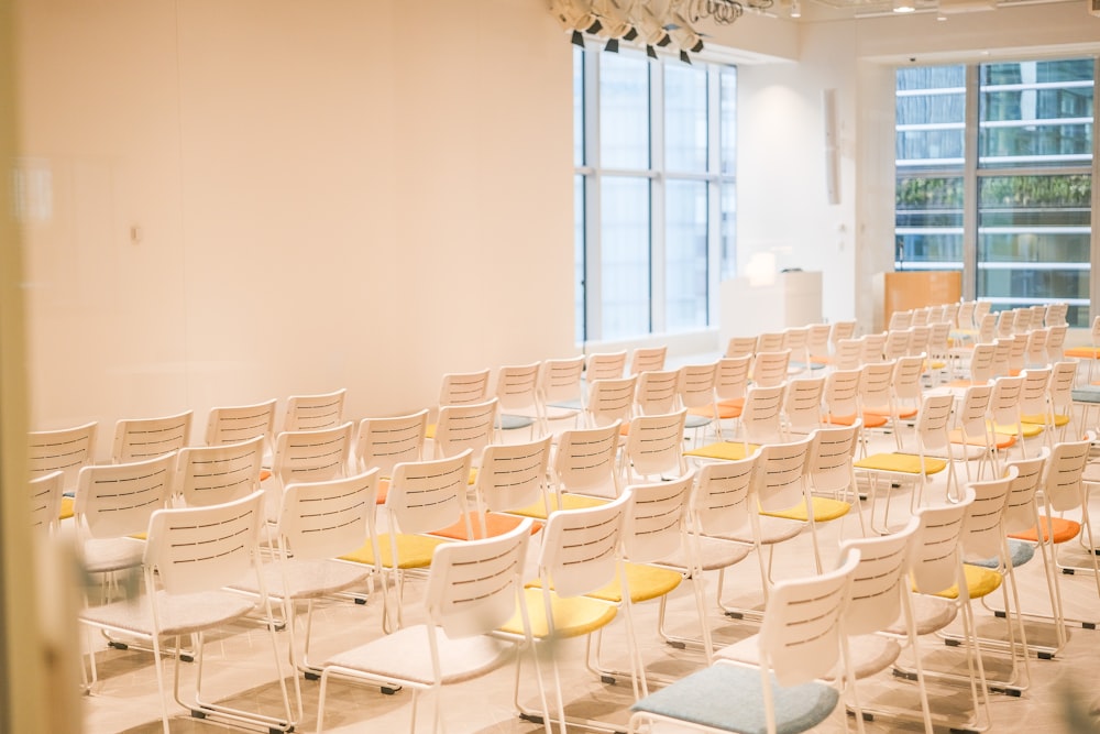 a room filled with lots of white chairs