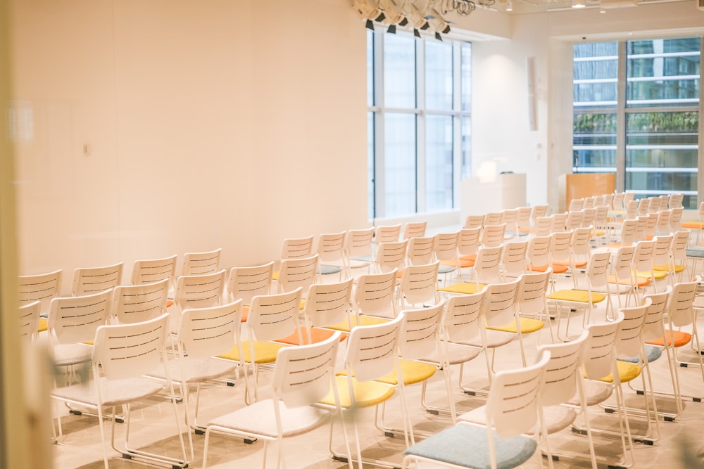 Une pièce remplie de nombreuses chaises blanches