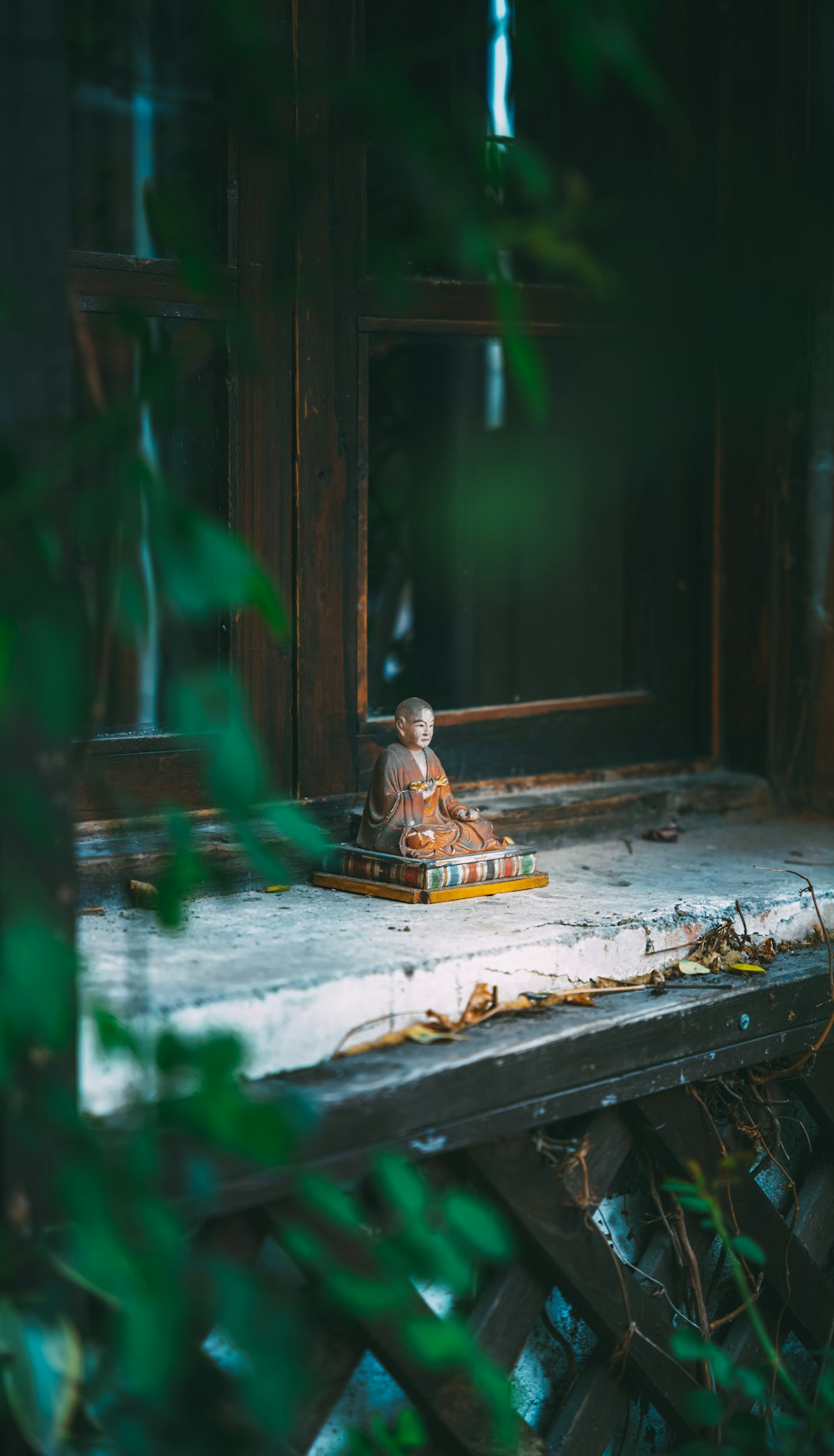 Eine kleine Buddha-Statue sitzt auf einem Holztisch