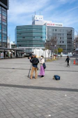 Journalist interviewing a local resident in an urban plaza.