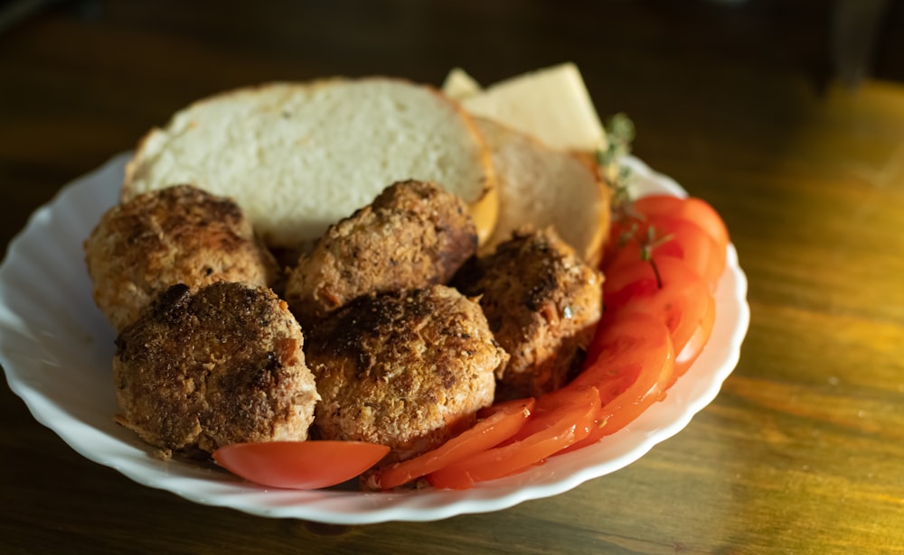 a white plate topped with meatballs and vegetables