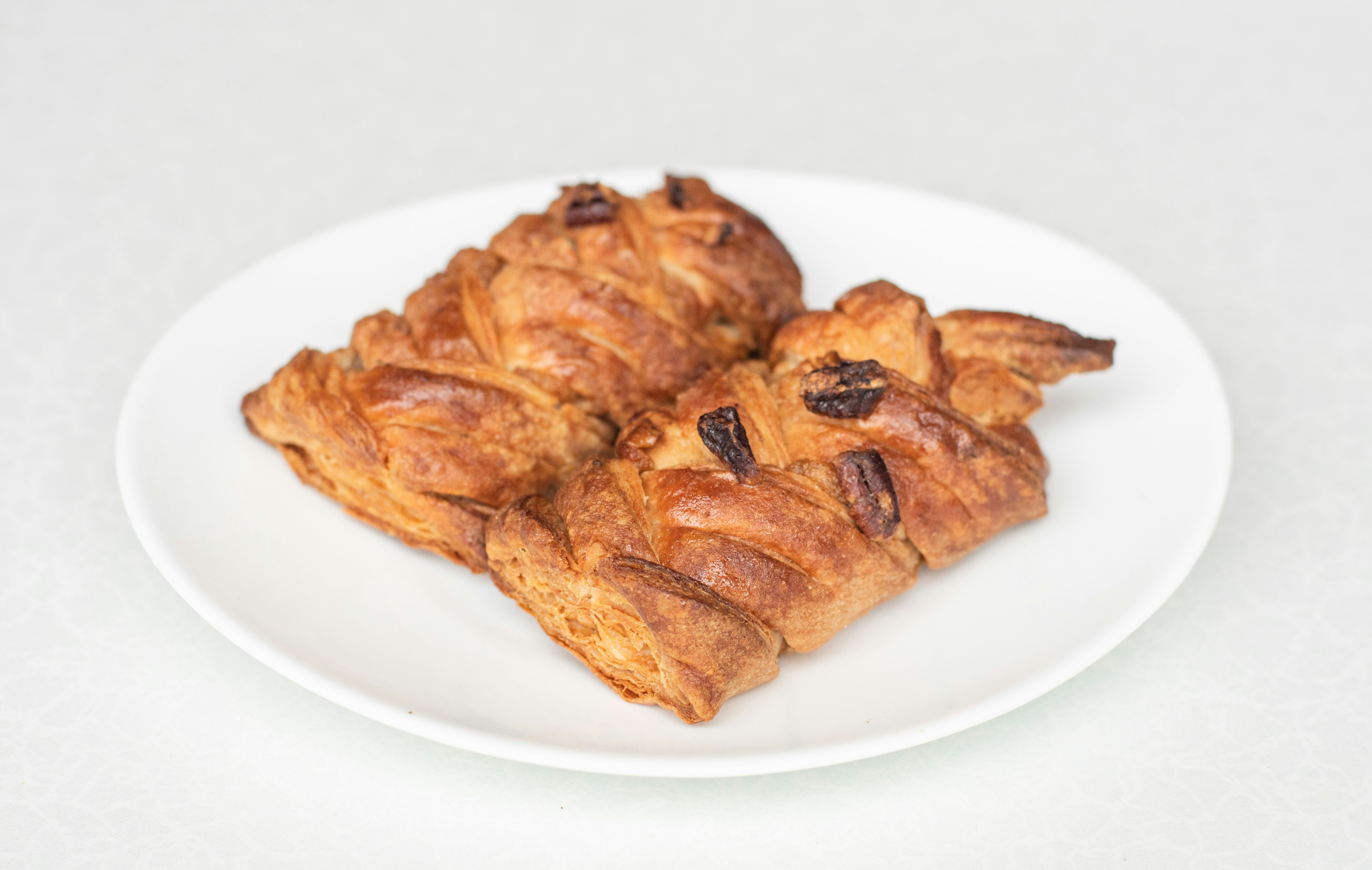a white plate topped with croissants on top of a table