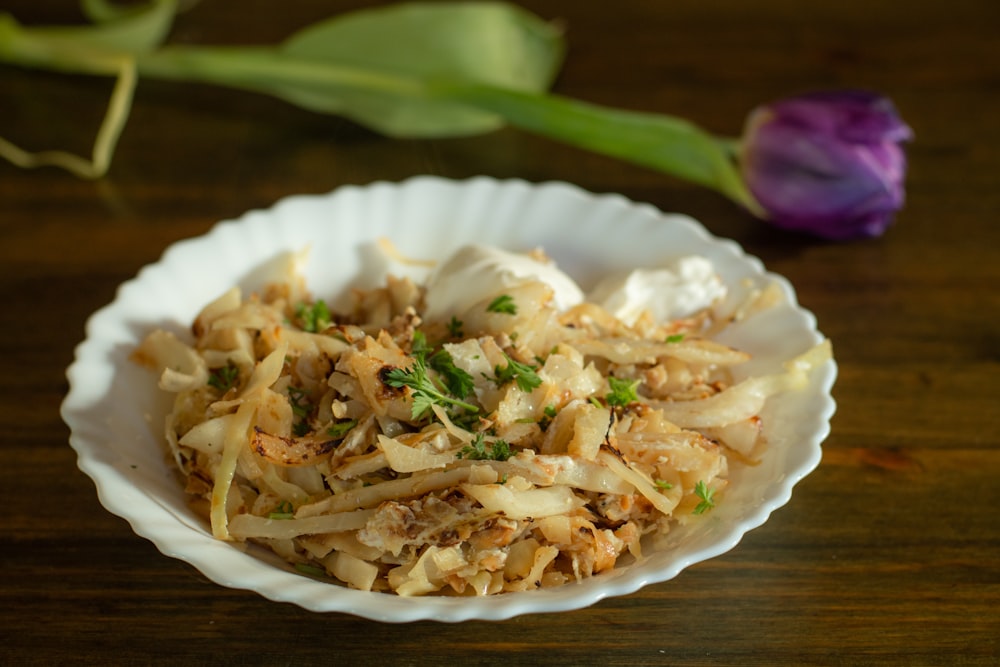 a white bowl filled with food on top of a wooden table