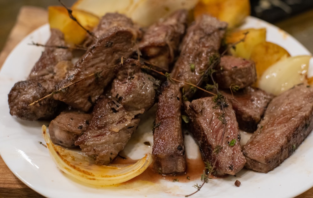 a white plate topped with steak and potatoes