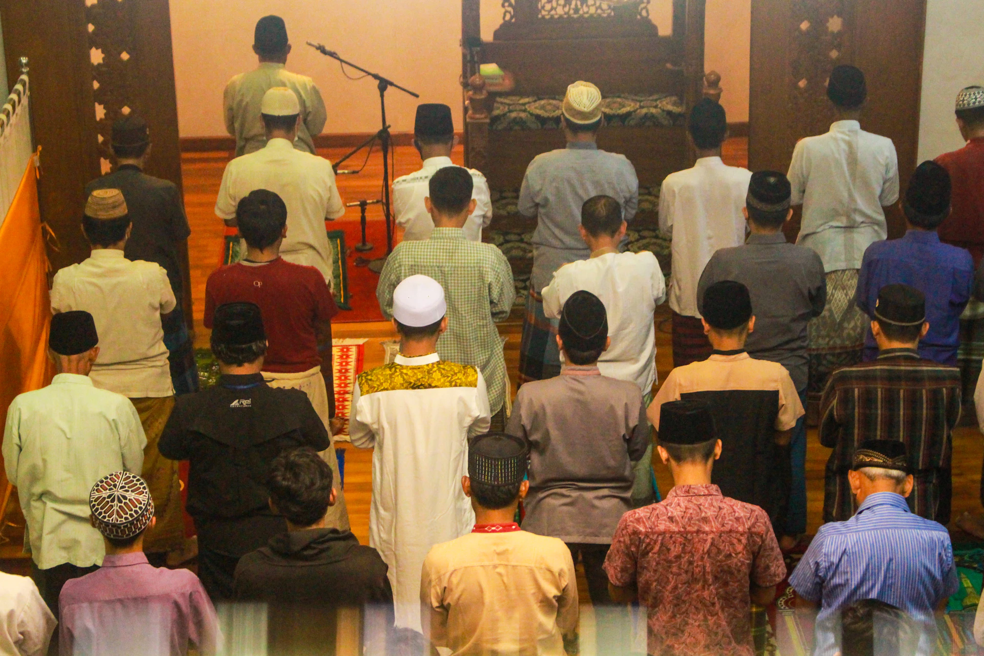 A diverse group of people praying together in a bright church hall.