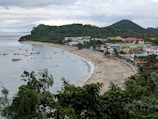 Scenic view of Florianópolis coastline with tourists walking along the shore