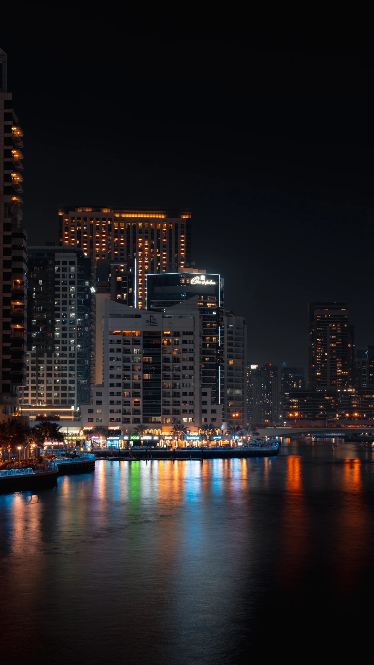 Dubai towers reflected in the water at night