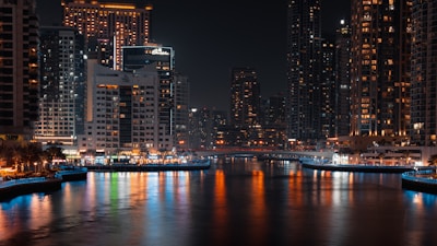 a city at night with lights reflecting in the water