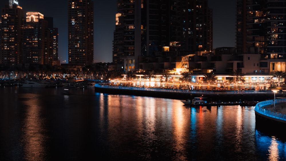 a city at night with a boat in the water