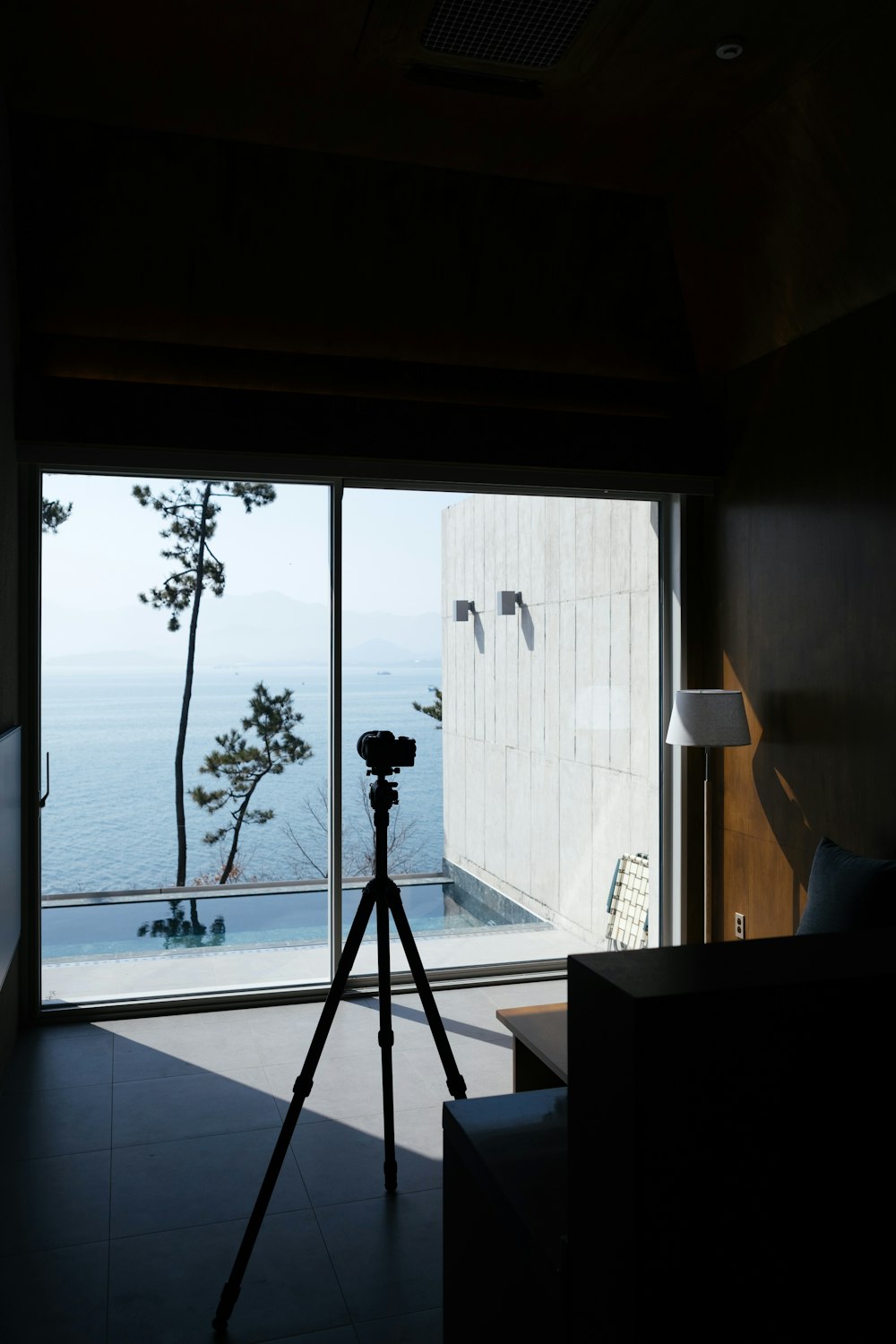 a tripod sitting in front of a window with a view of the ocean