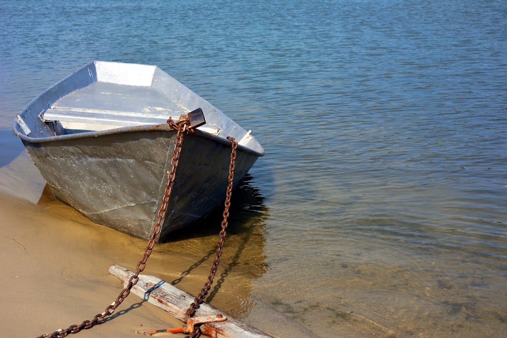 a boat tied up on the shore of a lake