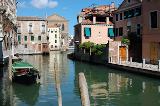 A charming canal lined with historic buildings in Venice, Italy, reflecting in the water.