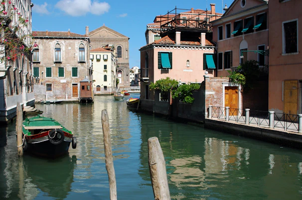 A charming canal lined with historic buildings in Venice, Italy, reflecting in the water.