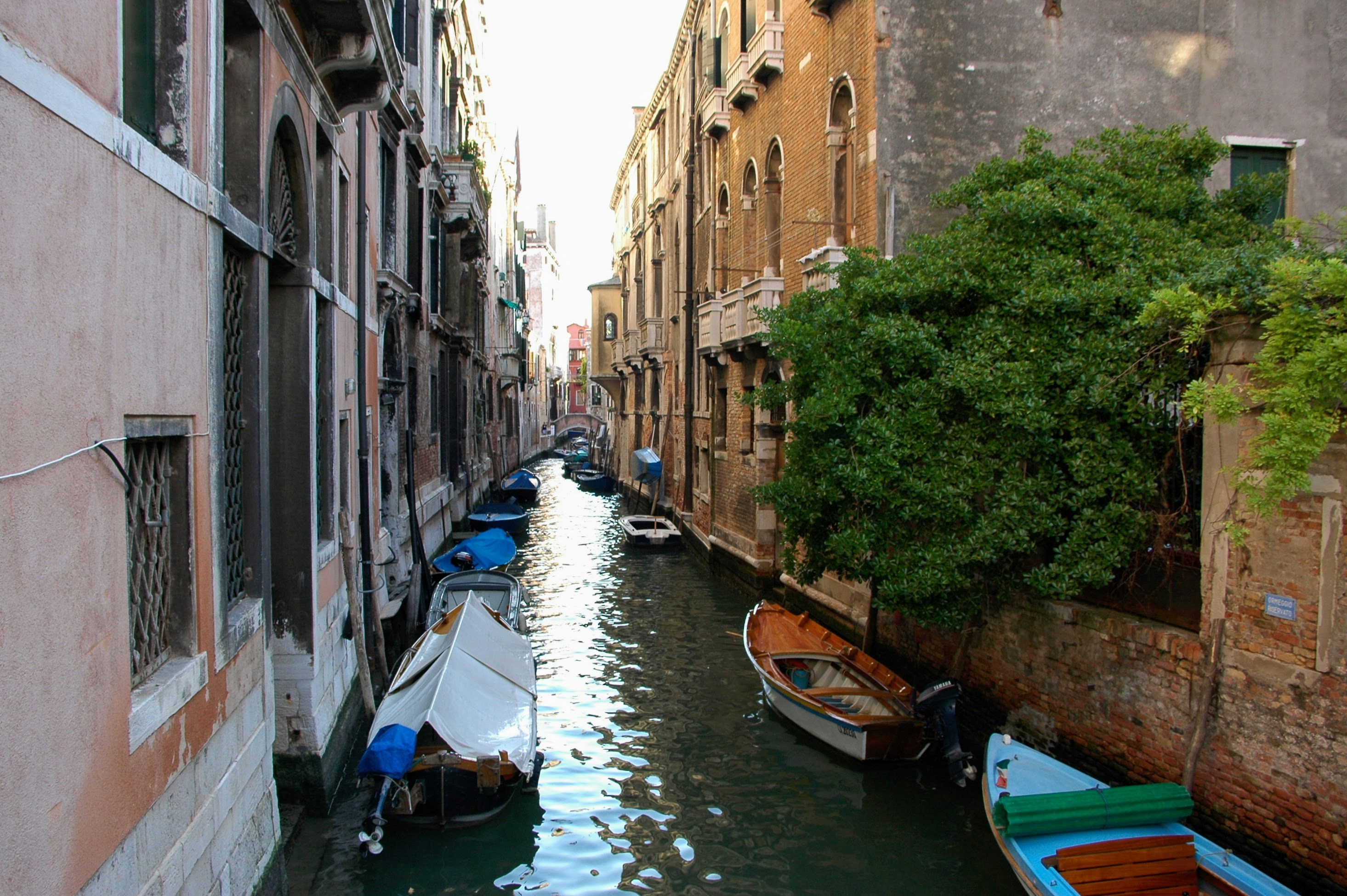 a narrow canal with several boats in it, 